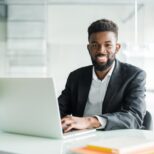 Optimized-portrait-handsome-african-black-young-business-man-working-laptop-office-desk